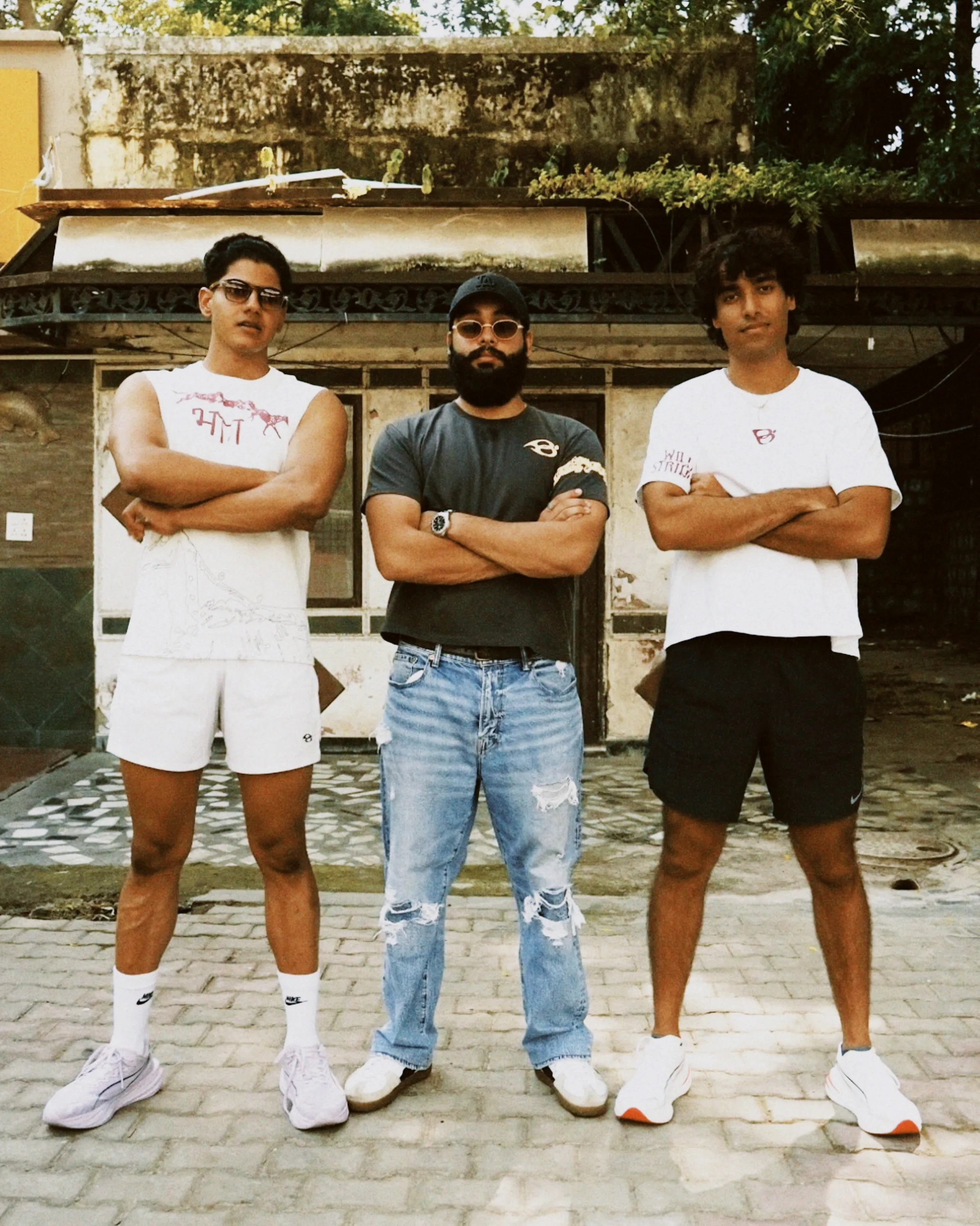 Three friends standing arms crossed in the Wild Strides tees