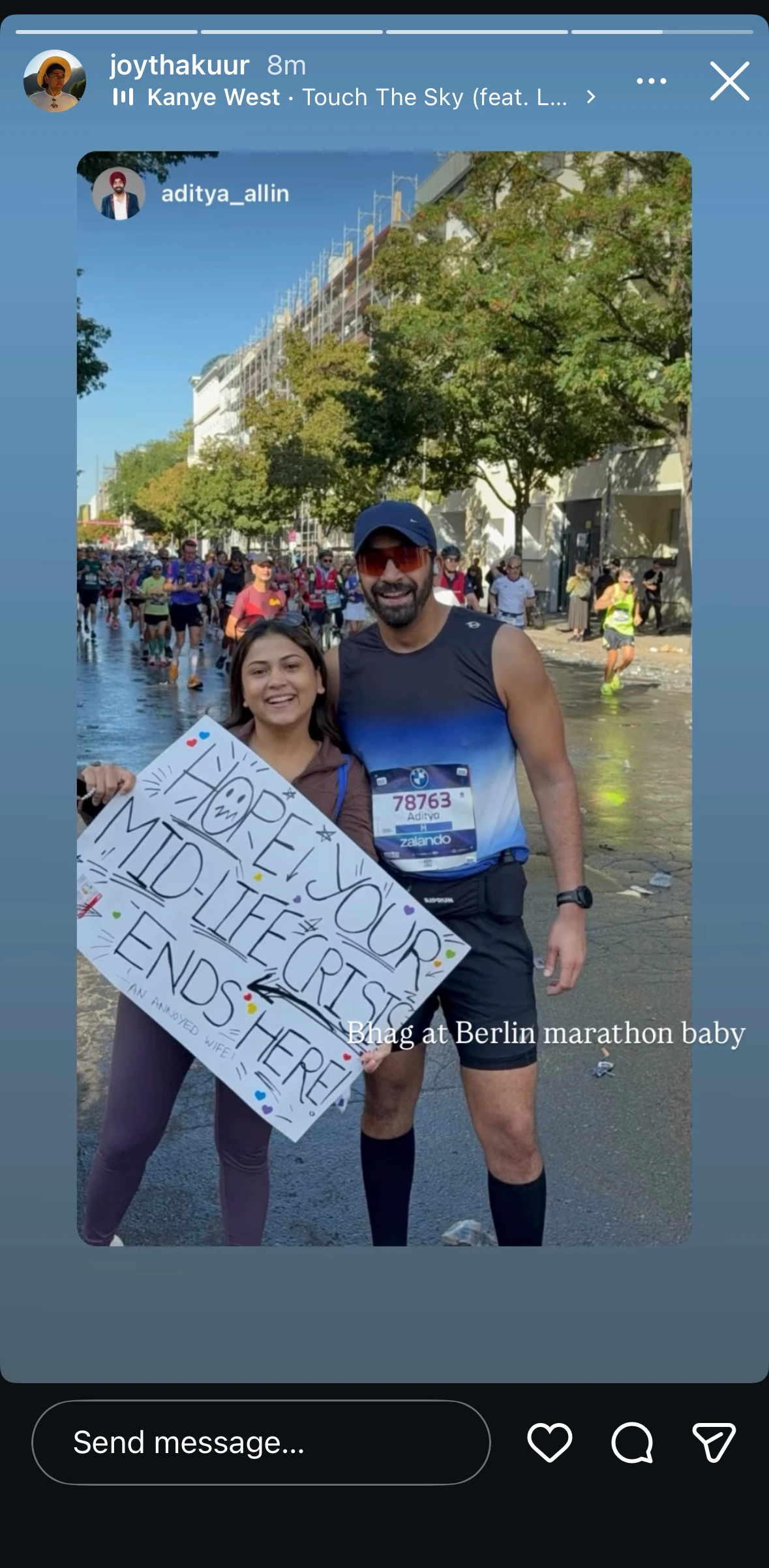 A friend's Story reposting the same member at the Berlin marathon finish, holding a hand-drawn sign with his wife, captioned "Bhag at Berlin marathon baby"