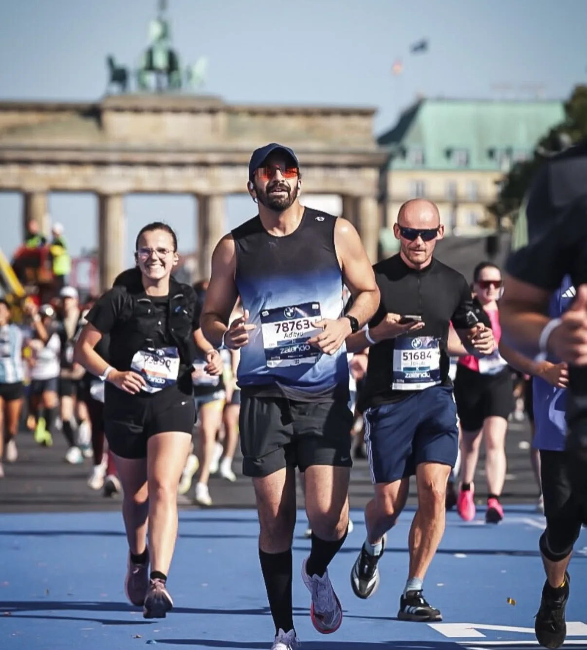 A runner in the Dark Aura Vest at the Berlin Marathon, the Brandenburg Gate behind him
