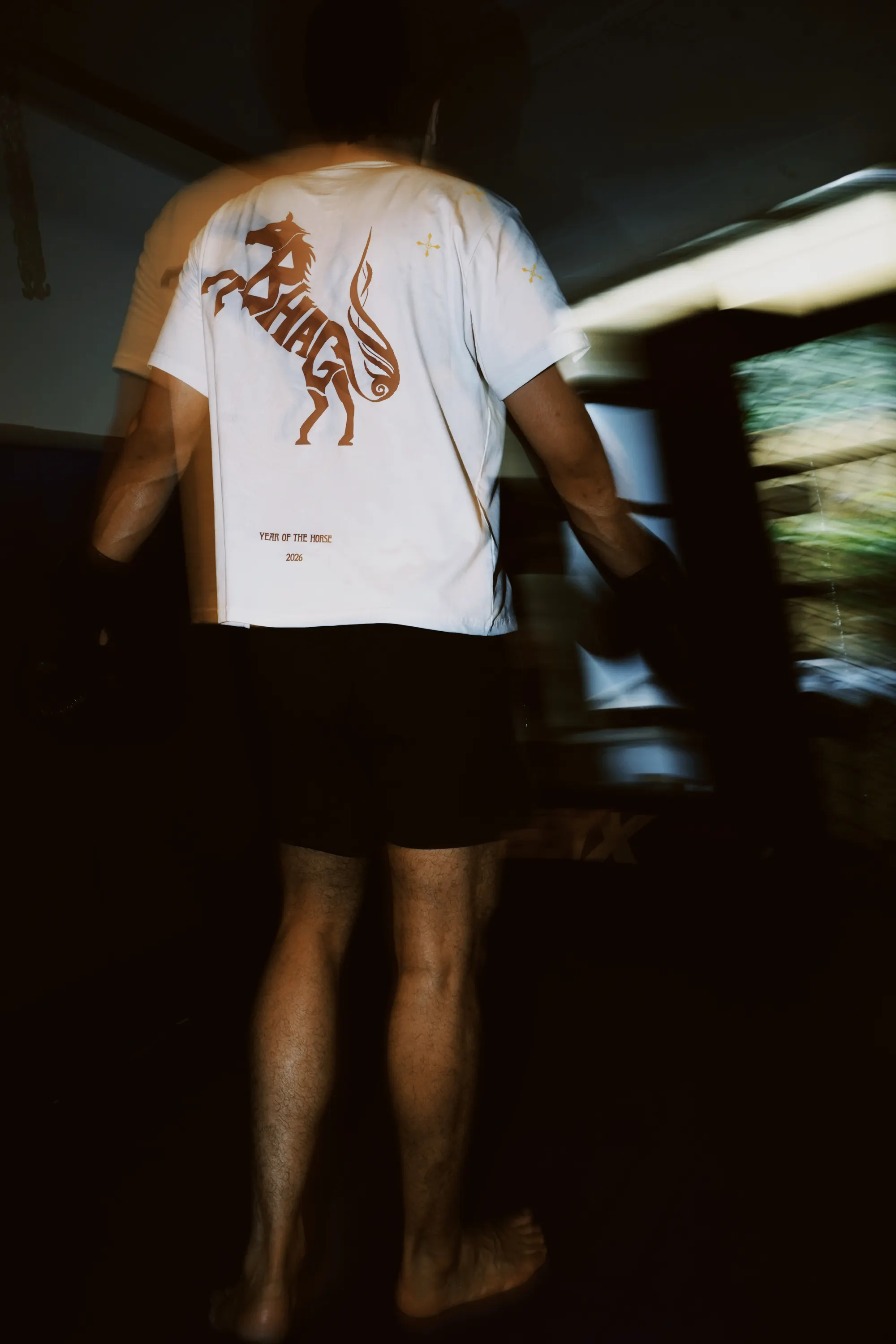 Wild Strides Tee in Ivory, back print, worn at the Combat Lab