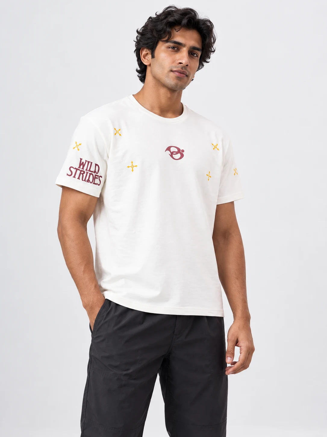 Wild Strides Tee in Ivory, styled on a model against a soft white-gray studio background